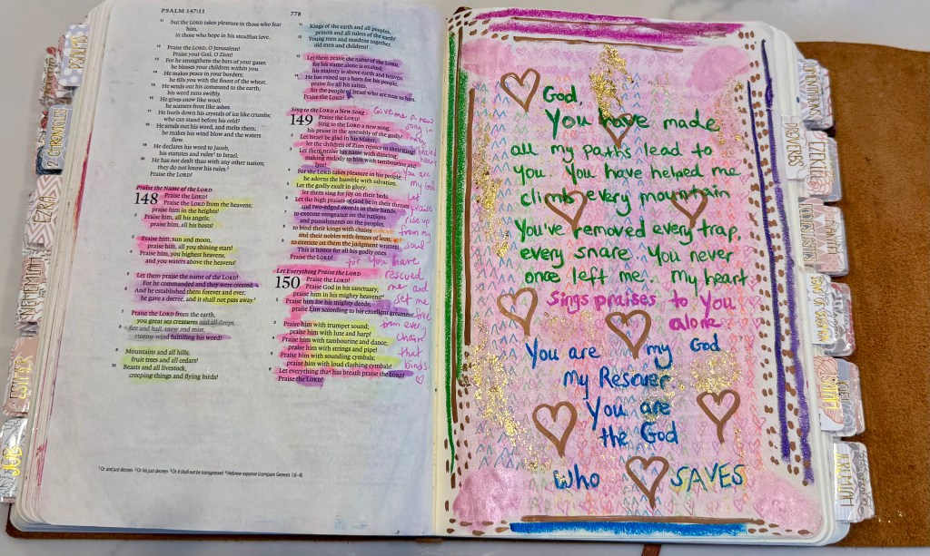 Open journaling Bible with Psalms on the left and a pink-and-gold art page on the right filled with handwritten prayers, hearts, and the words “You are my God, my rescuer… the God who saves.”